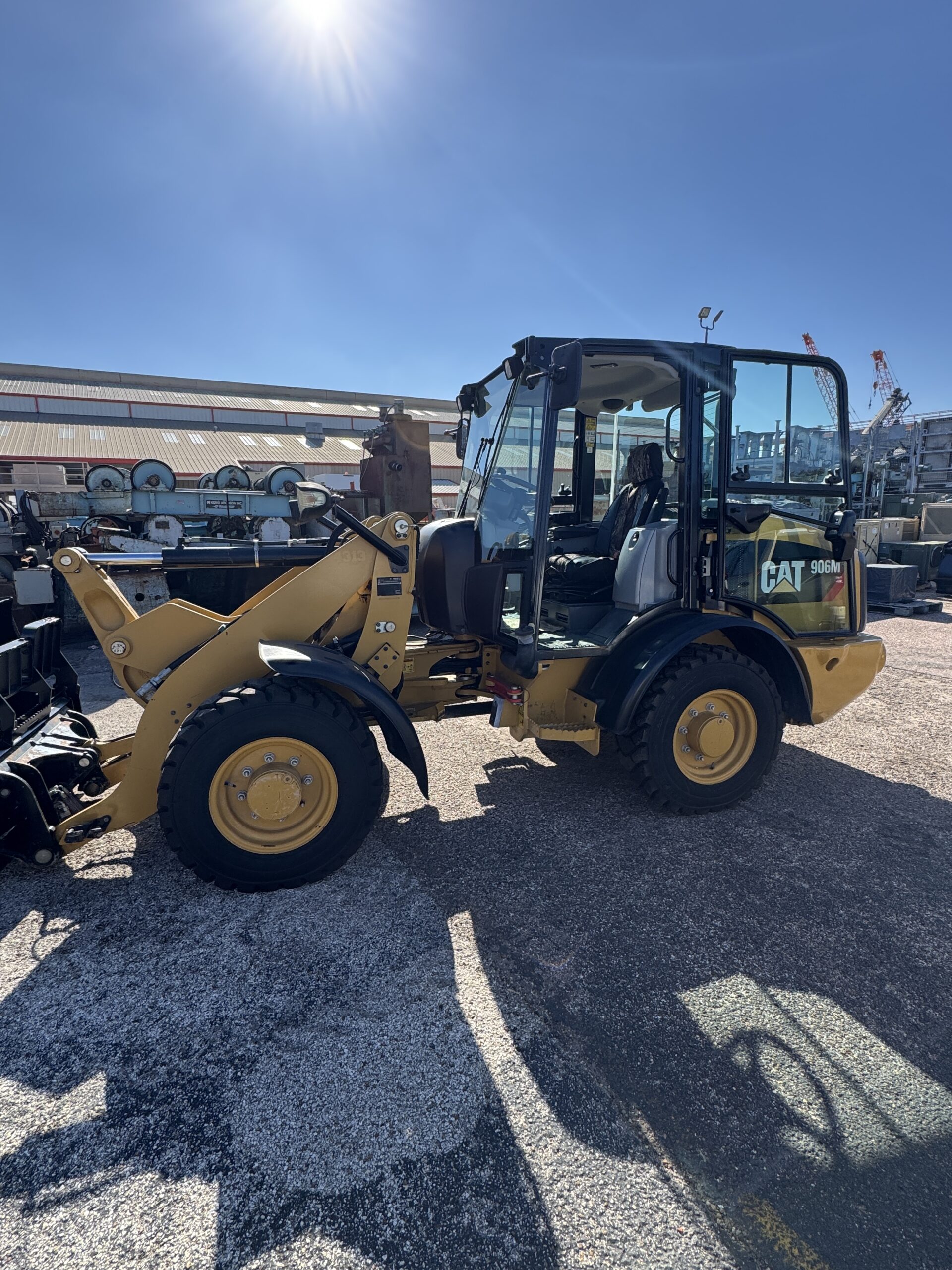 Side view of compact Cat 906M loader with bucket