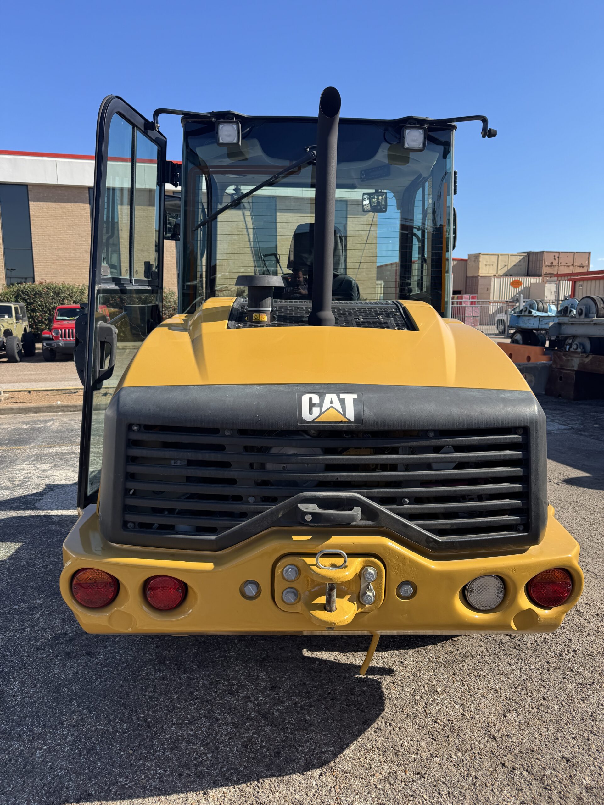 Rear view of compact Cat 906M loader with bucket