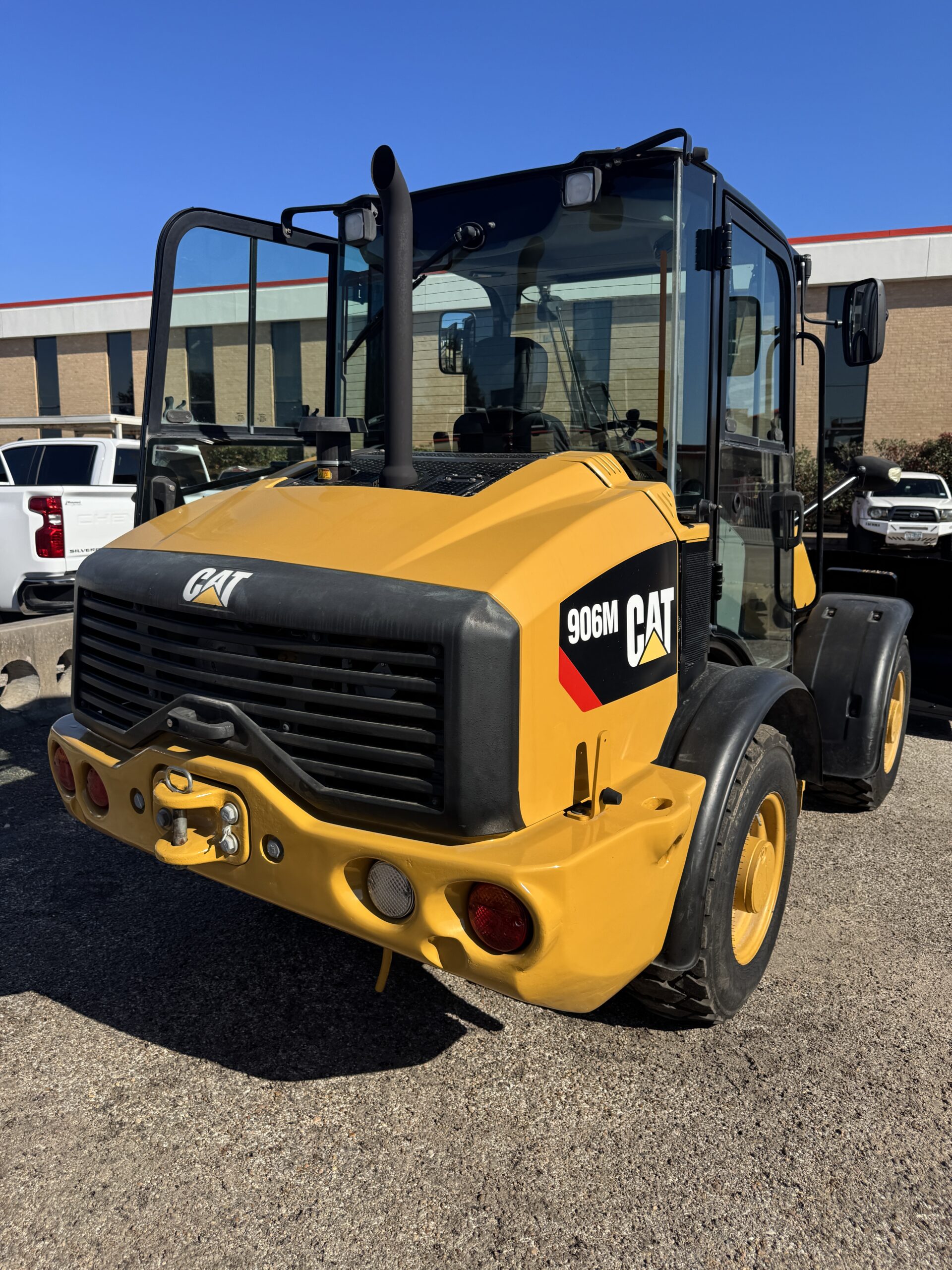 Right rear view of compact Cat 906M loader with bucket