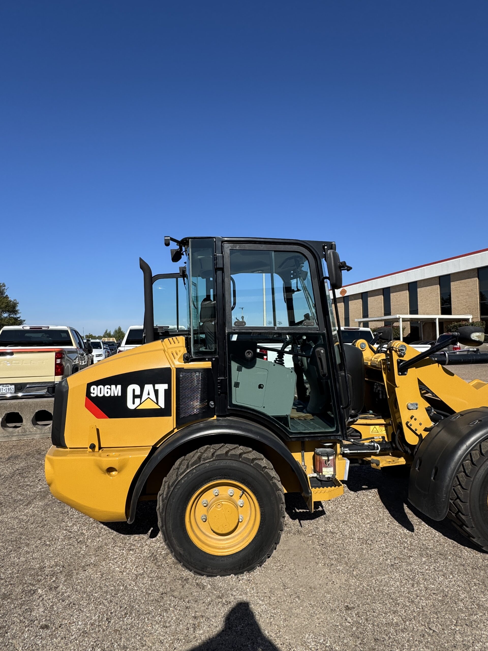Side view of compact Cat 906M loader with bucket