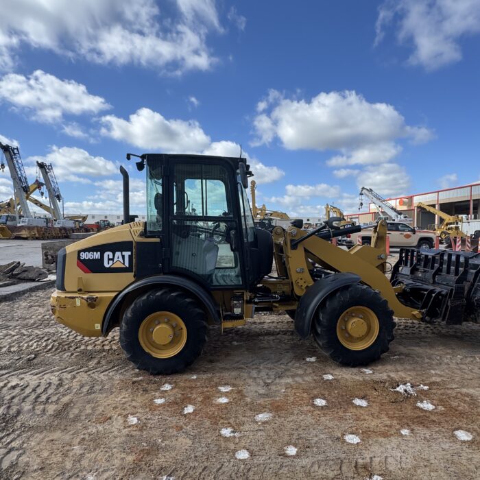 Side profile of compact 2019 Cat 906M loader showing quick coupler system for sale in Houston, TX.