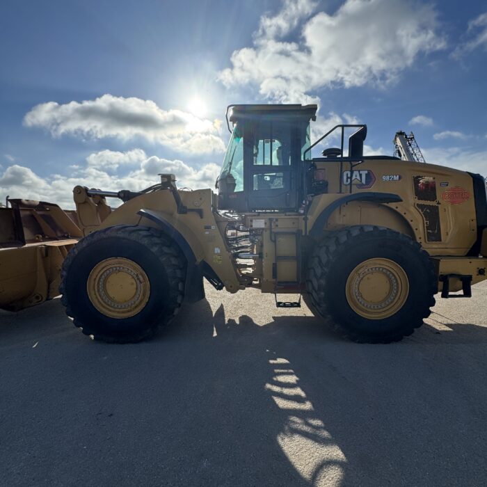 Side profile 2 of 982M loader showing large tire and robust frame