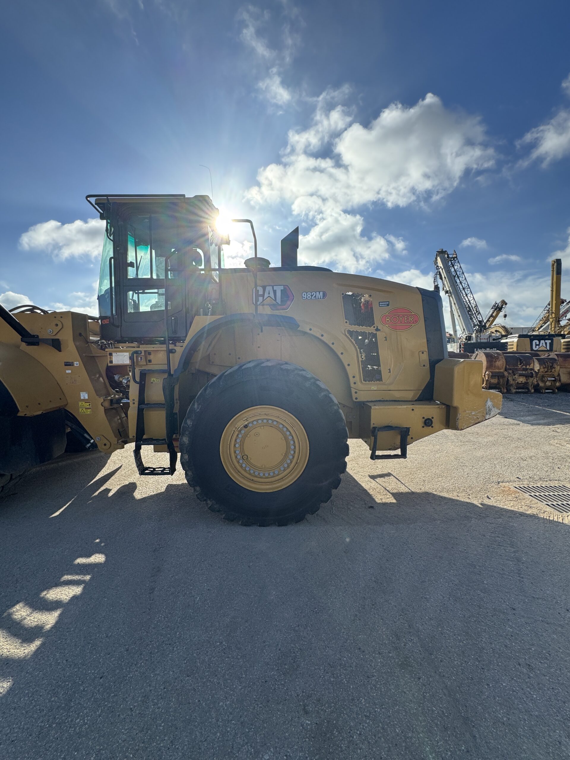 Side profile 3 of 982M loader showing large tire and robust frame